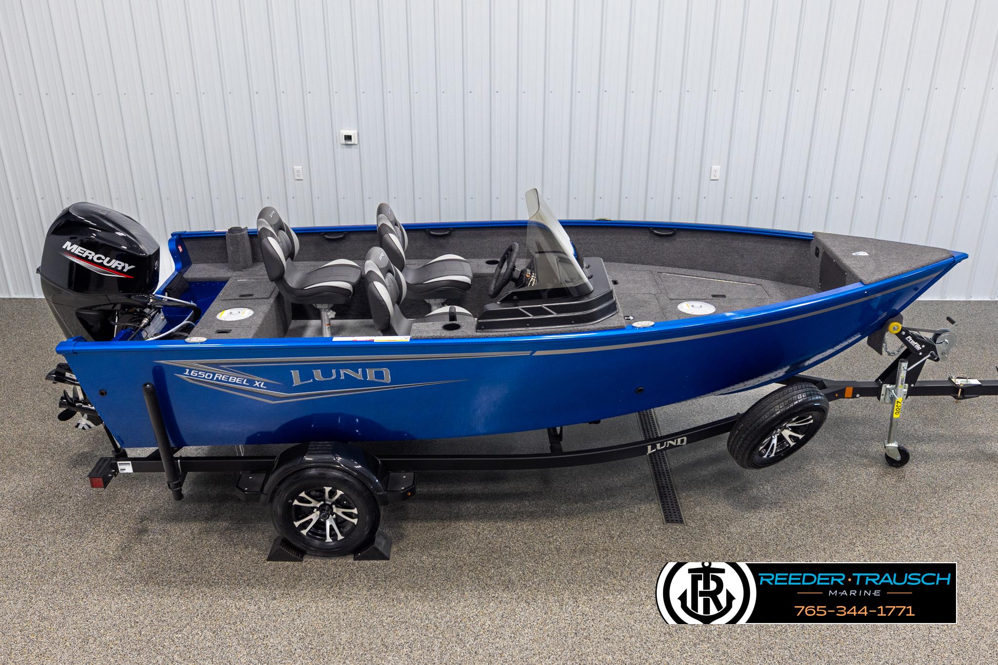 Lund Rebel XL SS 2025 Lund Rebel XL SS boat with Mercury engine on trailer, displayed indoors.