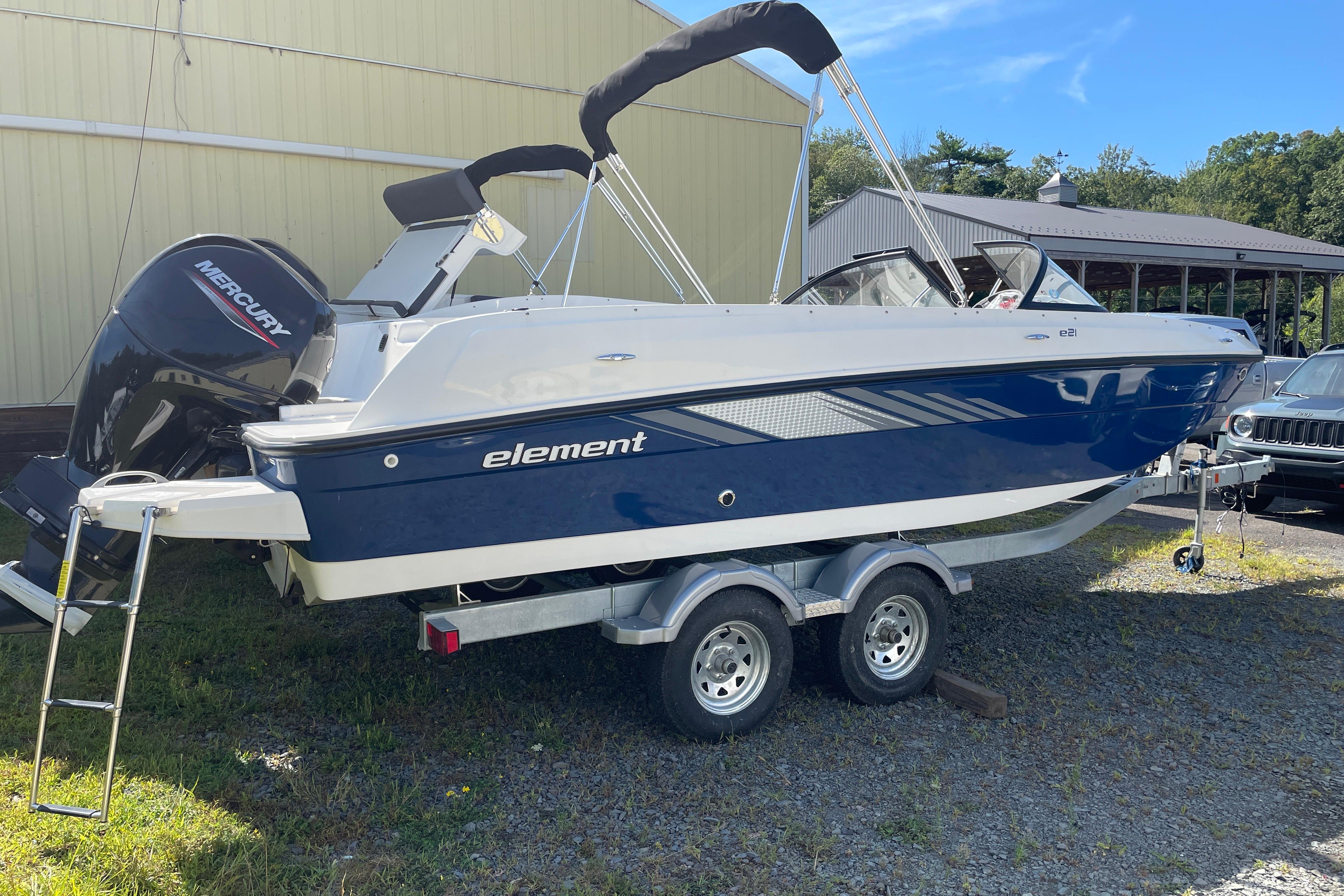 Bayliner Element E21 2024 Bayliner Element E21 boat on trailer, featuring a Mercury outboard motor.