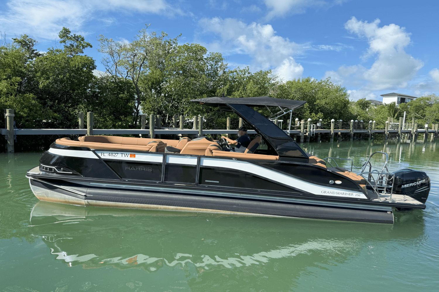 Harris Grand Mariner 250 2022 Harris Grand Mariner 250 pontoon boat on calm water, surrounded by lush greenery.