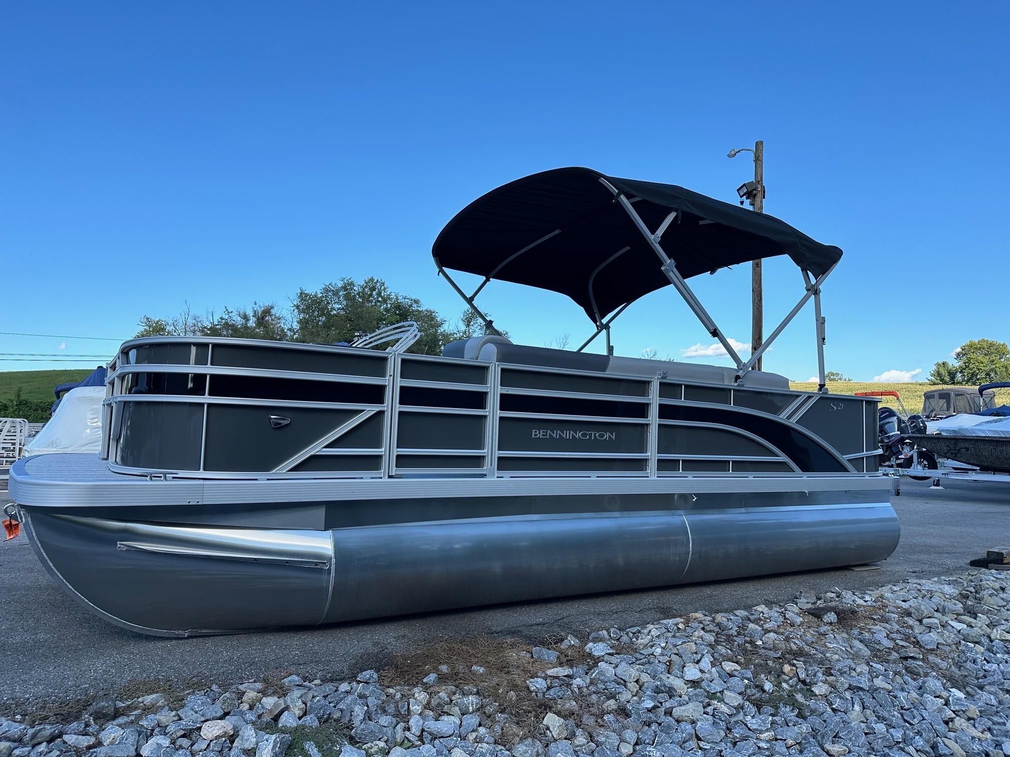 Bennington 21 SF Family / 4 Fishing seat (In Stock) 2025 Bennington 21 SF pontoon boat with canopy, parked on gravel.