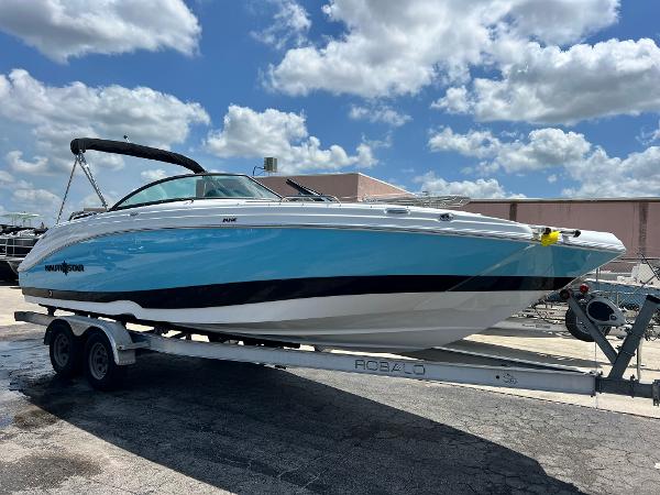 NauticStar 243 DC 2024 NauticStar 243 DC boat on a trailer under a partly cloudy sky.