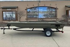 Tracker Grizzly 1860 Utility 2026 Tracker GRIZZLY 1860 Utility boat on trailer, parked outdoors.