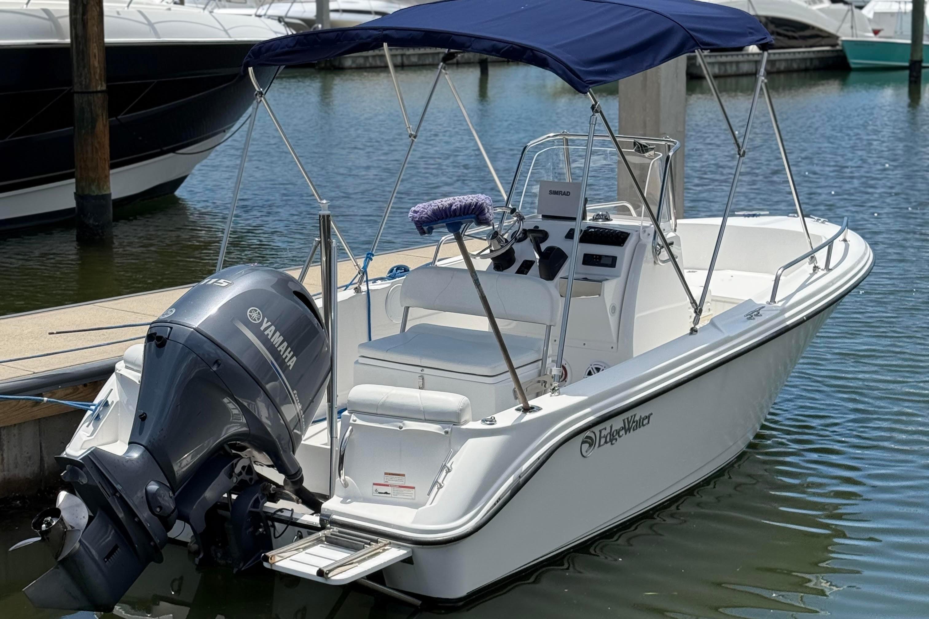 Edgewater 170CC 2019 Edgewater 170CC boat docked with Yamaha outboard motor and blue canopy.