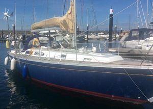 Rustler 36 Sailboat Rustler 36, 1993 model, docked in a marina with blue hull and tan sail cover.
