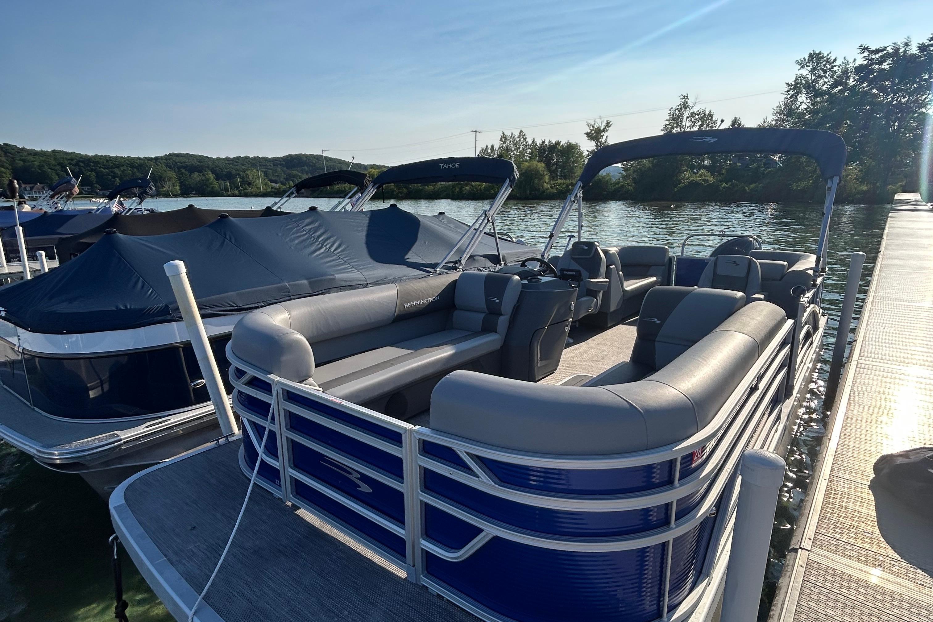 Bennington 22 SSR 2024 Bennington 22 SSR pontoon boat docked on a sunny lake.
