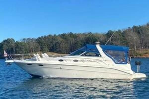 Sea Ray 330 Express Cruiser 1996 Sea Ray 330 Express Cruiser on a serene lake with forested shoreline.