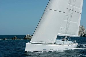 Nautor Swan 82 Sailing yacht Nautor Swan 82, 2008 model, gliding on open sea with rocky background.