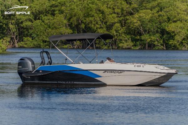 Starcraft SVX 211 OB 2023 Starcraft SVX 211 OB boat on calm water with lush green background.