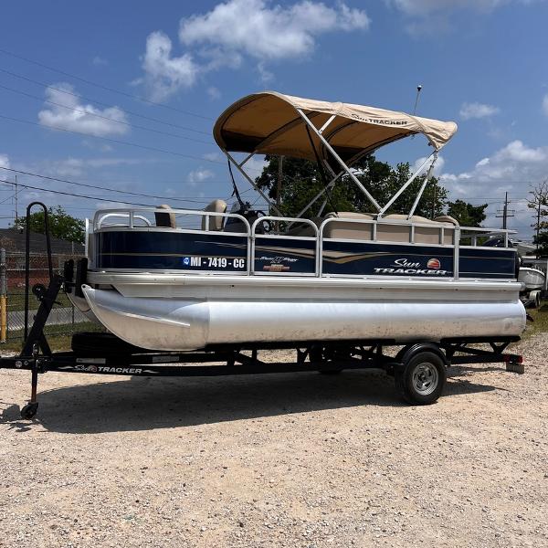 Sun Tracker Party Barge 18 DLX 2023 Sun Tracker Party Barge 18 DLX pontoon boat on a trailer.
