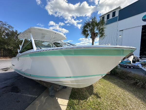 Blackfin 272 DC 2024 Blackfin 272 DC boat docked near a marina under a blue sky.
