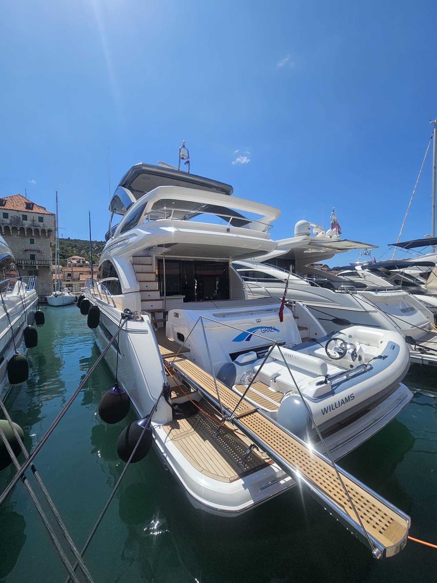Princess F62 Luxurious 2020 Princess F62 yacht docked in a sunny marina.