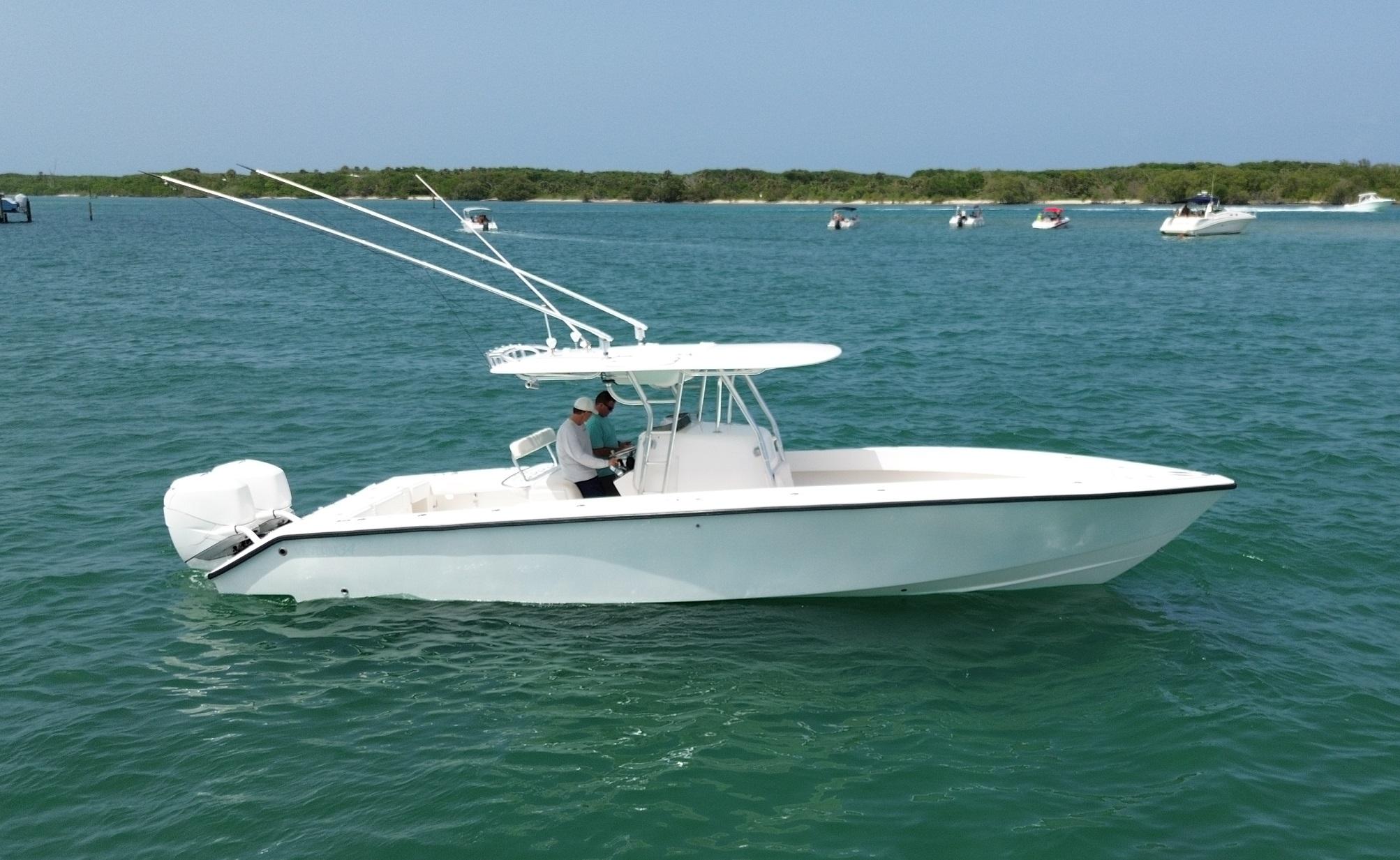 Venture 34 Open 2006 Venture 34 Open boat on calm water, with distant shoreline and other boats.