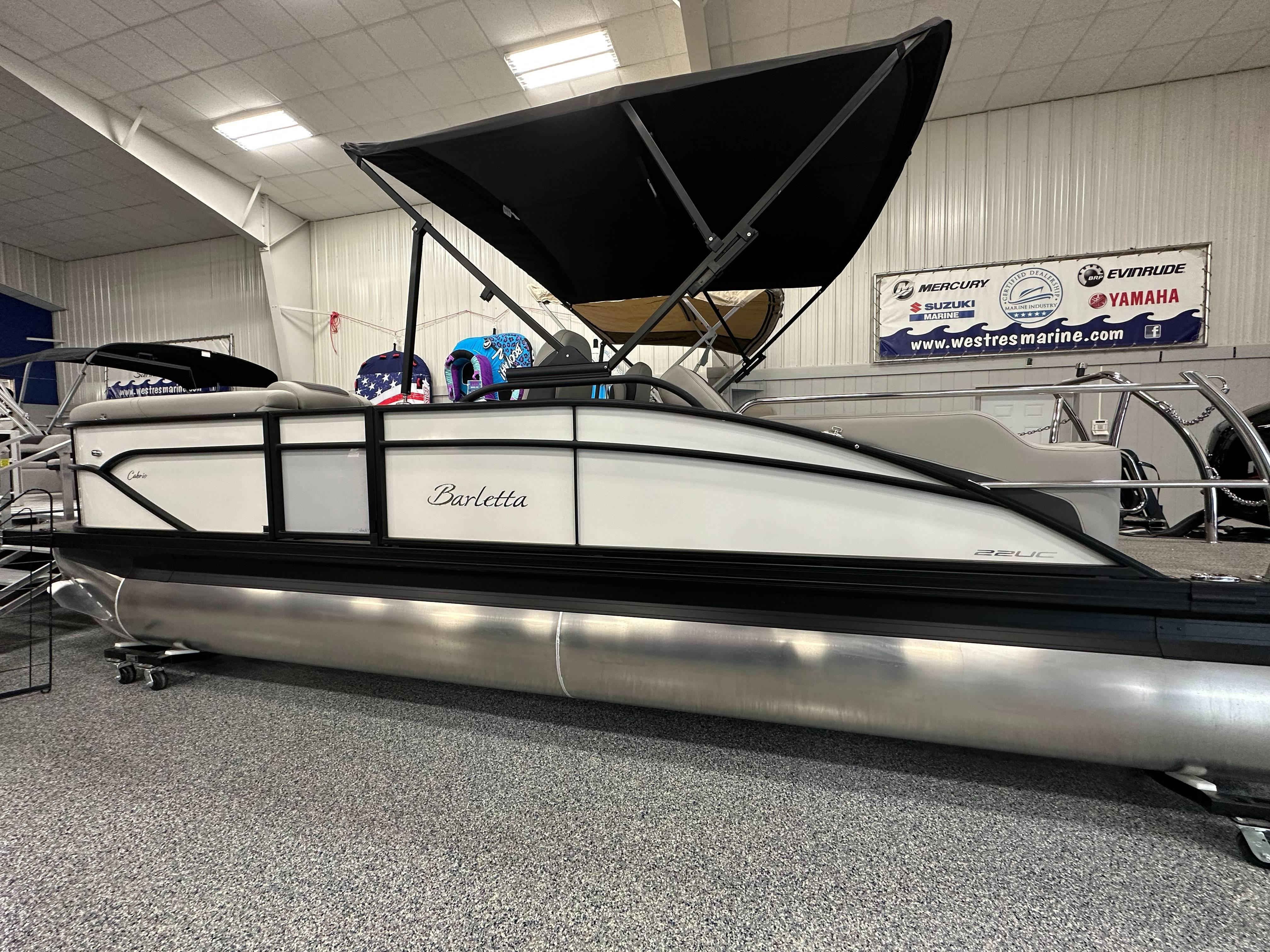 Barletta Cabrio 22UC 2025 Barletta Cabrio 22UC pontoon boat displayed indoors with black canopy.