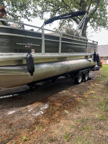 Sun Tracker SportFish 22 XP3 2024 Sun Tracker SportFish 22 XP3 pontoon boat on a trailer, parked outdoors.