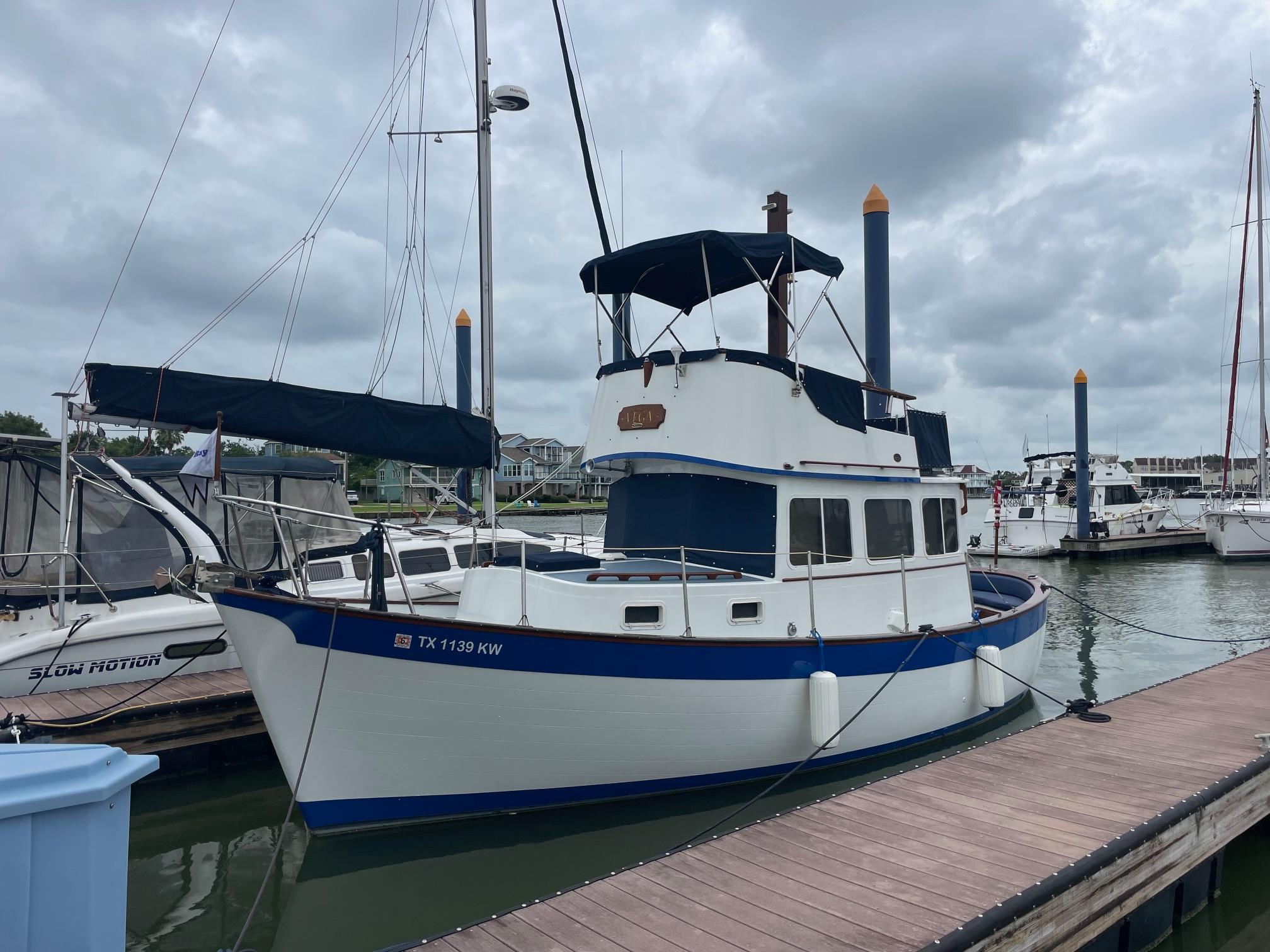 Willard Marine Vega 30 1973 Willard Marine Vega 30 boat docked at marina under cloudy skies.