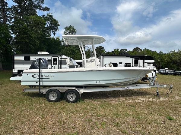 Robalo 226 Cayman 2023 Robalo 226 Cayman boat on trailer, parked outdoors near RVs.