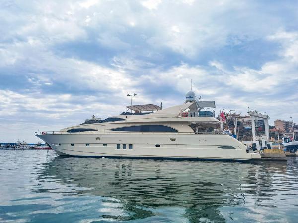 Astondoa 95 Luxury 2002 Astondoa 95 yacht docked in a marina under a cloudy sky.