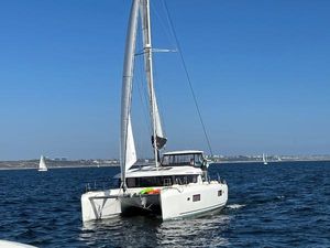Lagoon 42 2020 Lagoon 42 catamaran sailing on open water under clear blue skies.