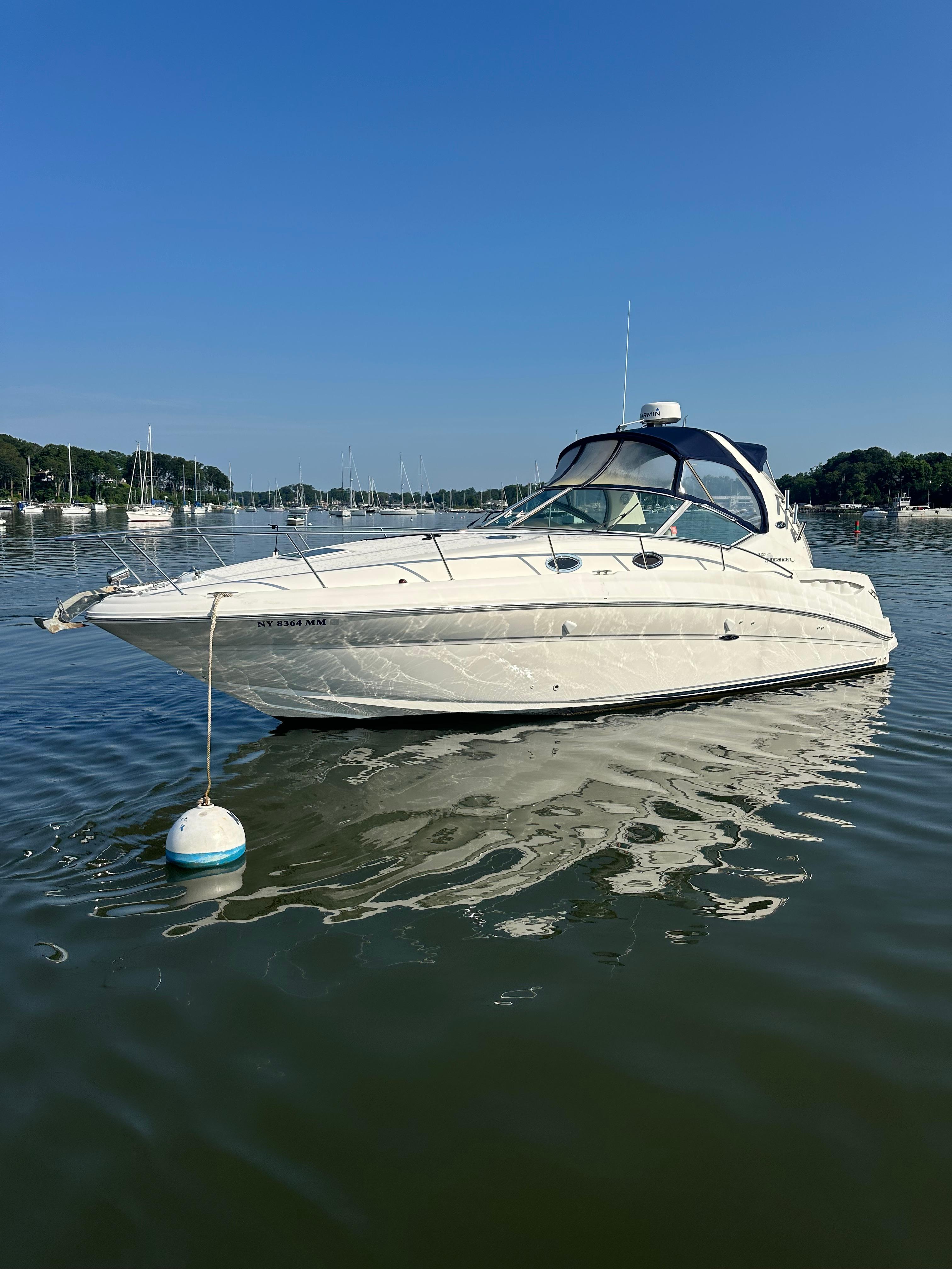 Sea Ray 320 Sundancer 2004 Sea Ray 320 Sundancer yacht anchored on calm water under clear blue sky.