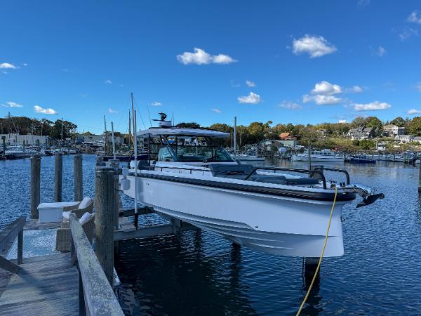 Axopar 37 Sun Top 2022 Axopar 37 Sun Top boat docked at a marina under a clear blue sky.