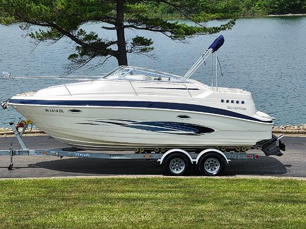 Glastron GT 249 2008 Glastron GT 249 boat on trailer by a lake.