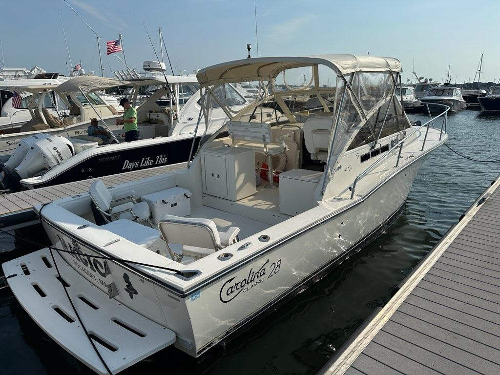 Carolina Classic 28 2005 Carolina Classic 28 boat docked at marina, featuring spacious deck and canopy.