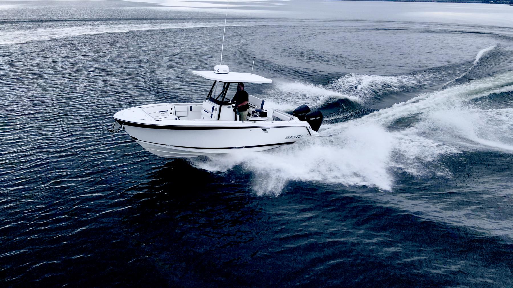 Blackfin 252 CC 2023 Blackfin 252 CC boat cruising on open water, creating dynamic waves.