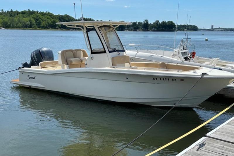 Scout 235 XSF 2021 Scout 235 XSF boat docked on a calm lake under clear skies.