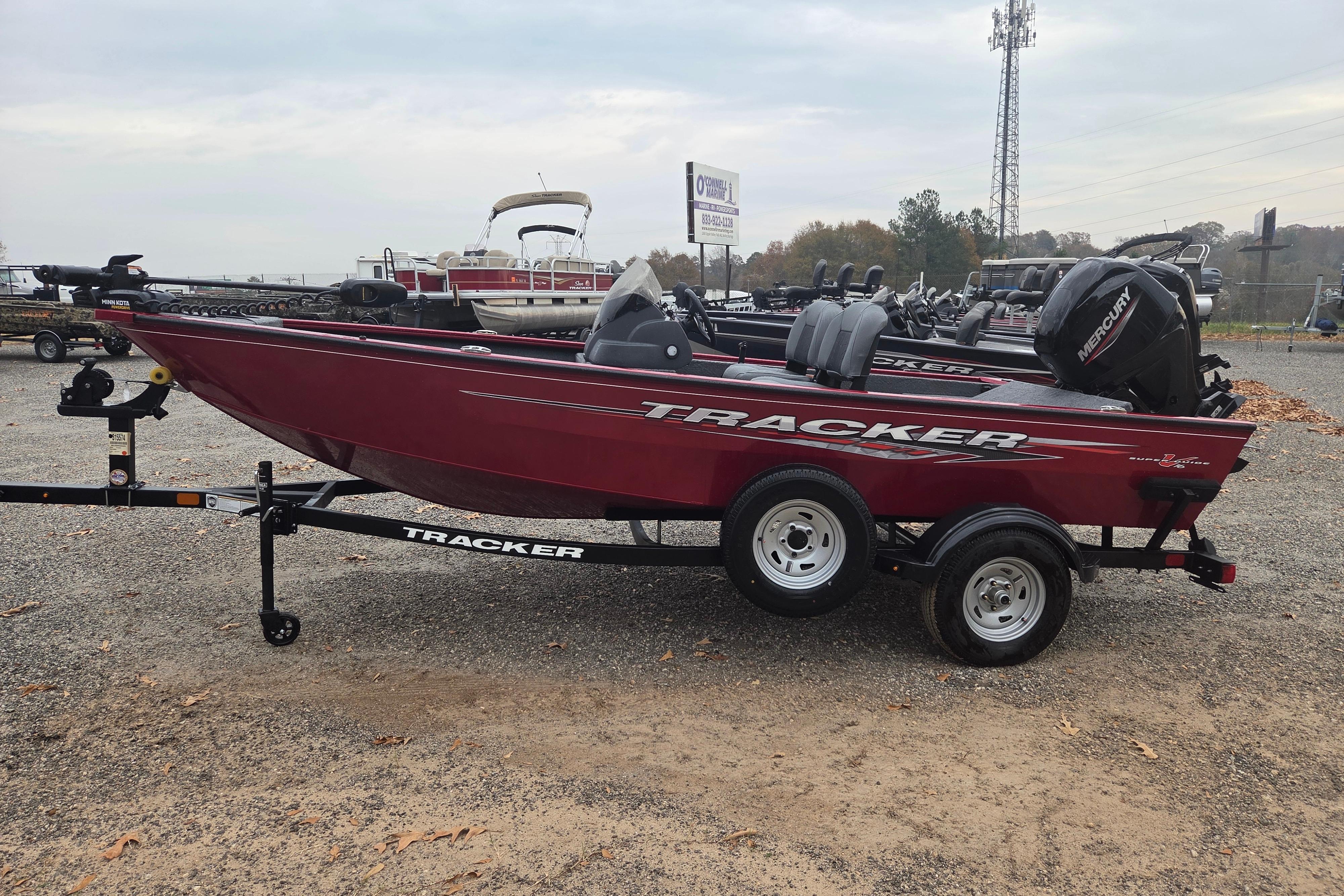 Tracker Super Guide V-16 SC 2025 Tracker Super Guide V-16 SC boat on trailer, red exterior, parked outdoors.