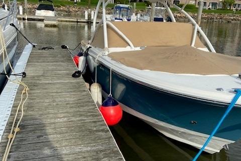 Edgewater 245 CX 2015 Edgewater 245CX boat docked at marina with protective cover.