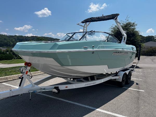Moomba Max 2025 Moomba Max boat on trailer in sunny parking lot.