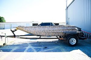 Edge Duck Boats 1556 DB 2023 Edge Duck Boats 17 on trailer, parked outdoors near a building.