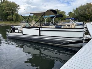 Premier 230 Sunsation Angler 4pt 2024 Premier 230 Sunsation Angler 4pt pontoon boat docked on a calm lake.