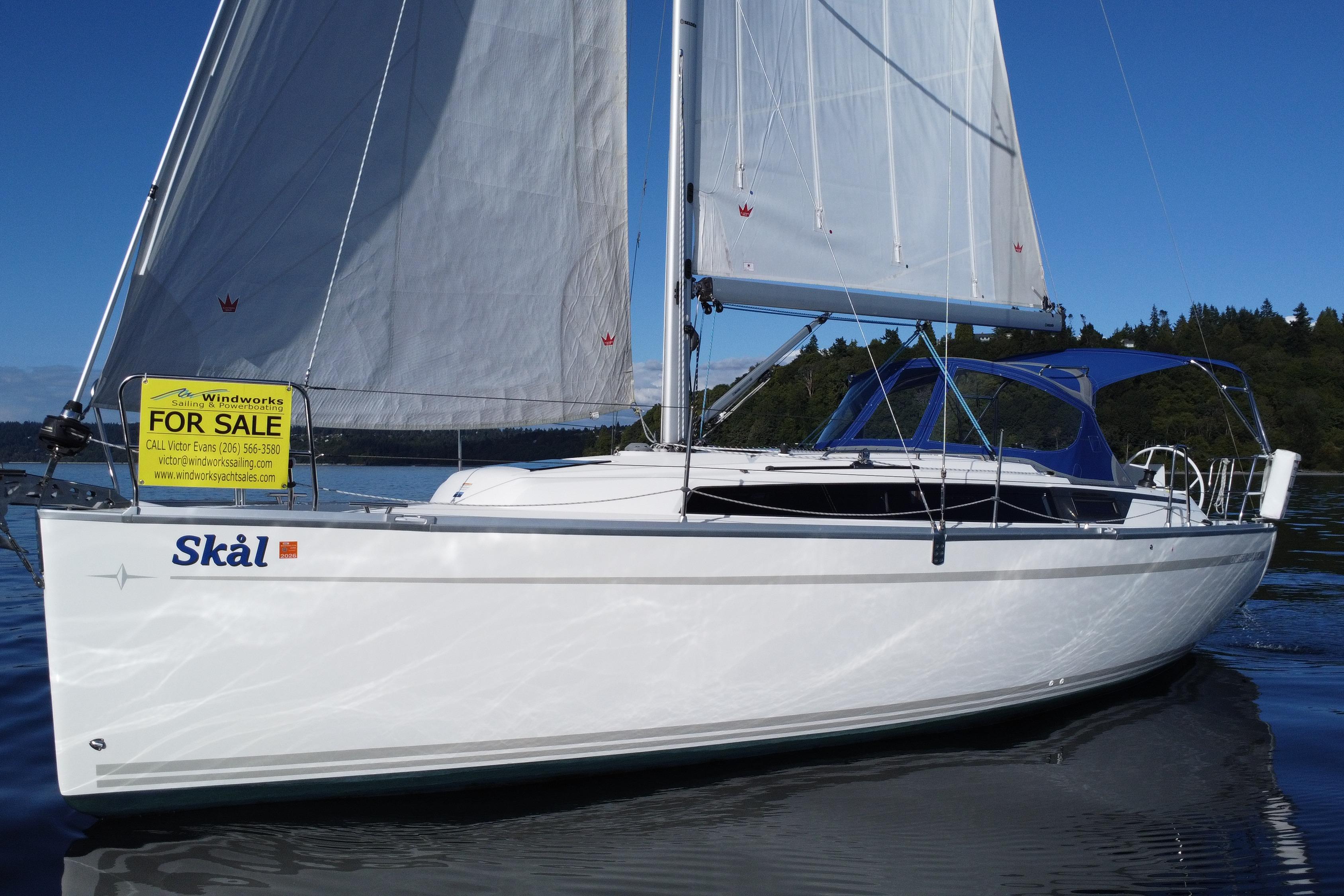 Bavaria Cruiser 34 2021 Bavaria Cruiser 34 sailboat for sale on calm water, featuring white sails and blue canopy.
