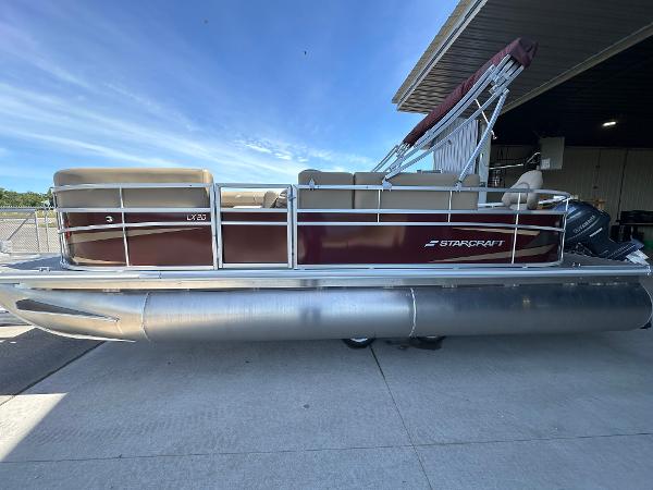 Starcraft LX20F 2025 Starcraft LX20F pontoon boat with maroon exterior, docked under a clear blue sky.