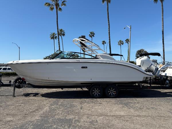 Sea Ray SDX 270 Outboard 2025 Sea Ray SDX 270 Outboard boat on trailer, parked under palm trees.