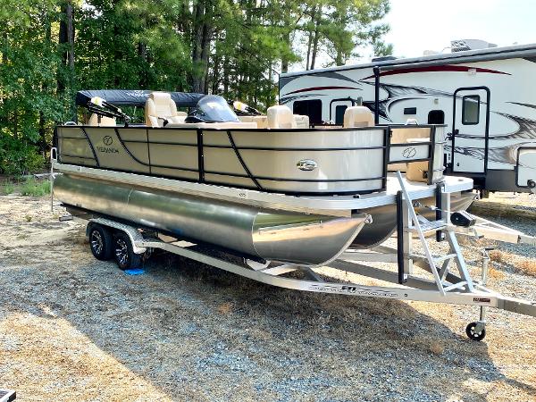 Veranda Fish VF22F4 Deluxe Tri-Toon 2025 Veranda Fish VF22F4 Deluxe Tri-Toon boat on trailer, parked outdoors near trees.