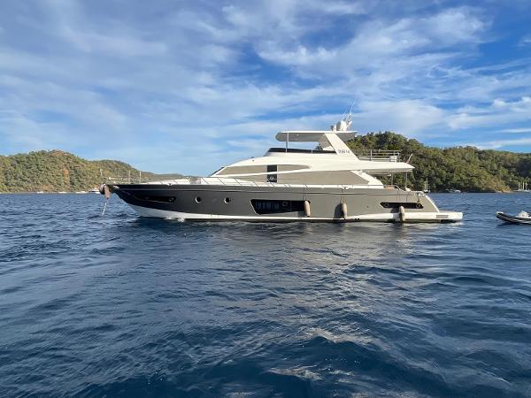 Custom 84 Luxurious 2018 Custom 84 yacht on serene blue waters, surrounded by lush green hills.