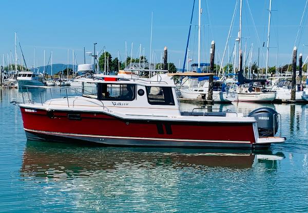 Ranger Tugs R-25 2024 Ranger Tugs R-25 boat docked in a marina with sailboats in the background.