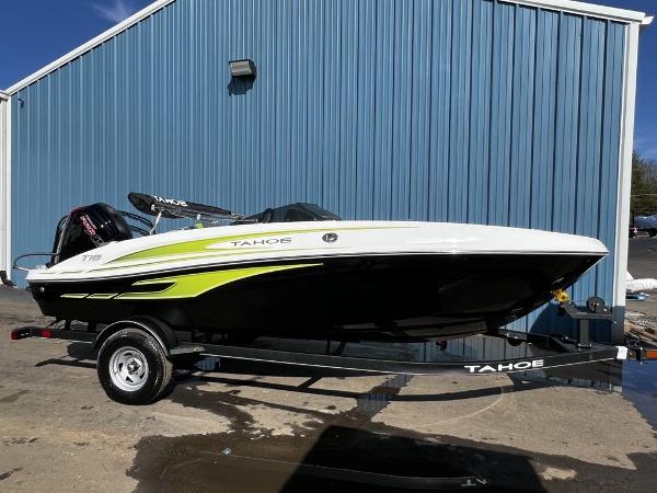 Tahoe T18 2023 Tahoe T18 boat on trailer, parked by blue building.