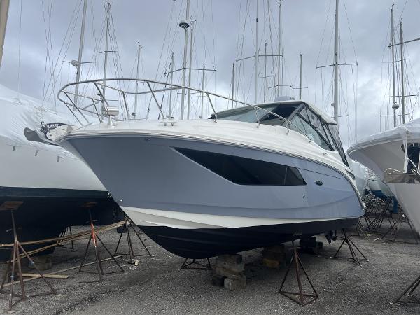 Sea Ray Sundancer 320 2023 Sea Ray Sundancer 320 boat on stands in a marina, overcast sky.