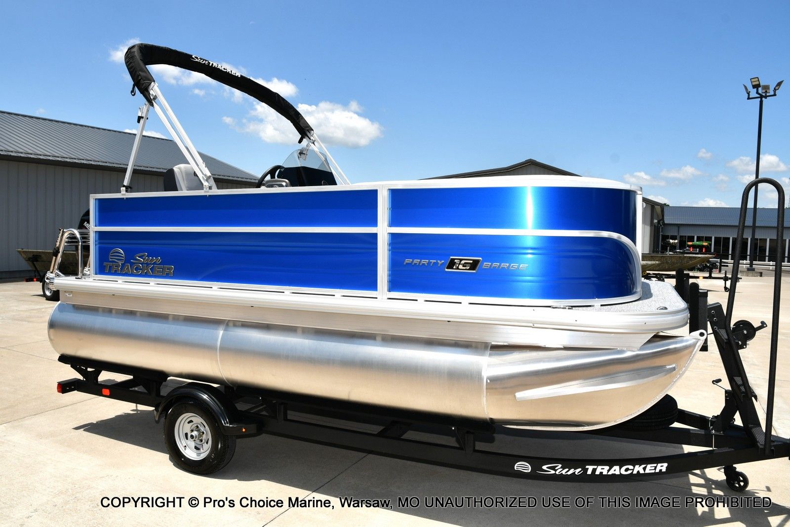 Sun Tracker Party Barge 16 2026 Sun Tracker Party Barge 16 pontoon boat on trailer, blue and silver design.