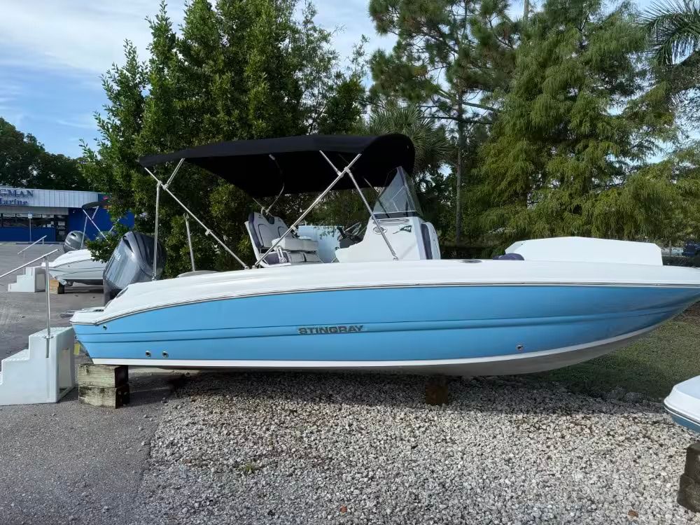 Stingray 206 CC 2025 Stingray 206 CC boat with blue hull and black canopy, displayed outdoors.