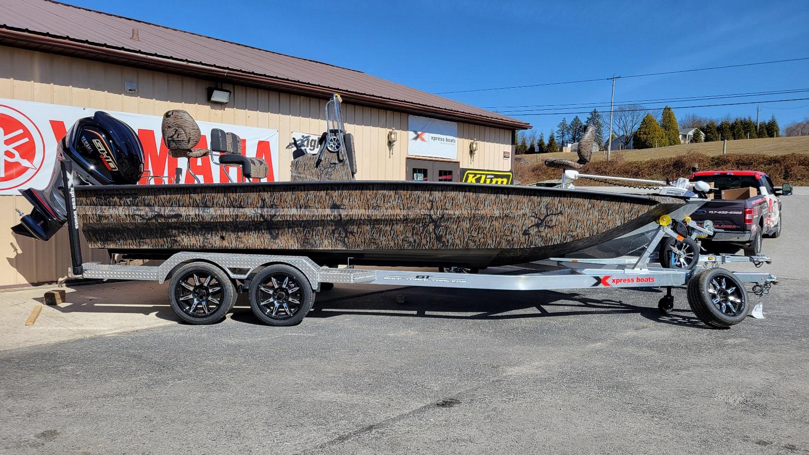 Xpress X23B Bay, Yamaha Vmax 250 SHO (On Order) ETA September Xpress X23B Bay boat with Yamaha Vmax 250 SHO, parked on a trailer outside a dealership.