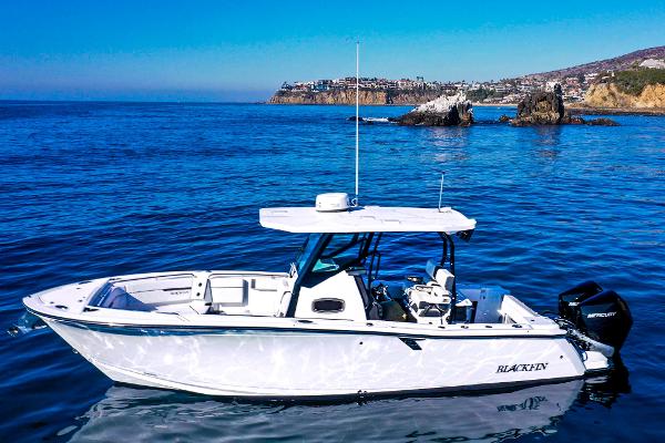 Blackfin 272 CC 2023 Blackfin 272 CC boat on calm ocean near rocky coastline.