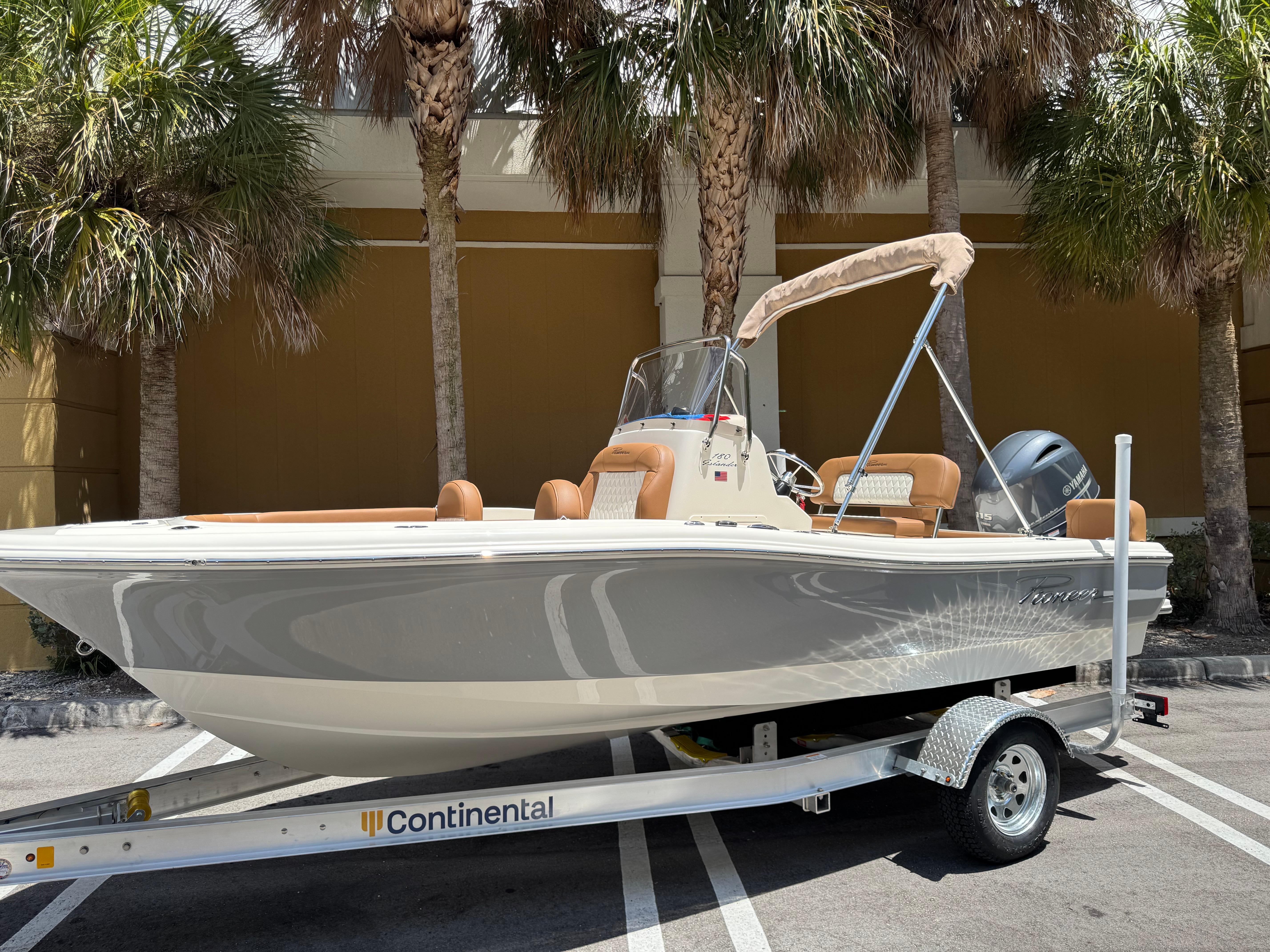 Pioneer 180 Islander 2026 Pioneer 180 Islander boat on trailer, parked under palm trees.