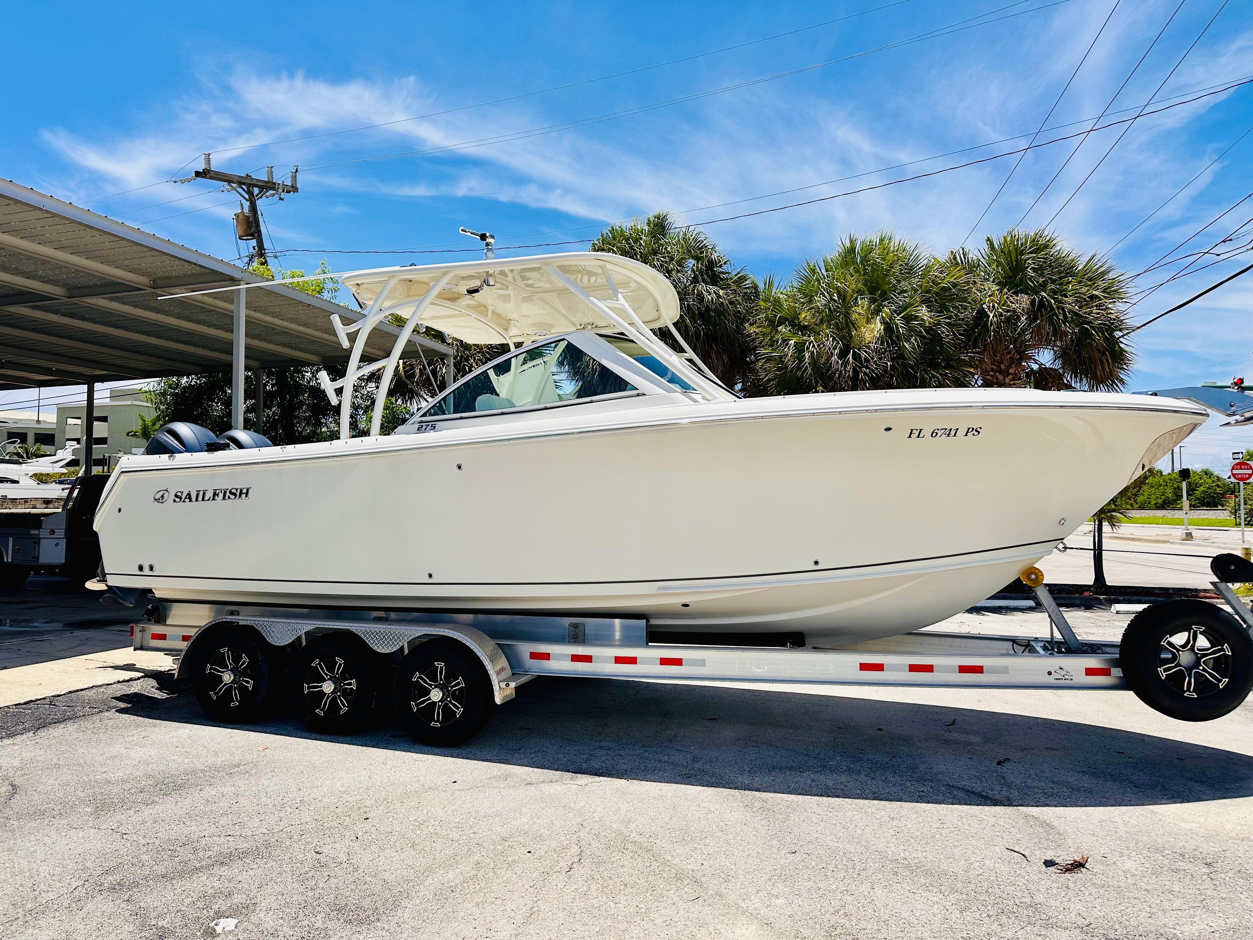 Sailfish 275 DC 2014 Sailfish 275 DC boat on trailer, parked outdoors under clear blue sky.