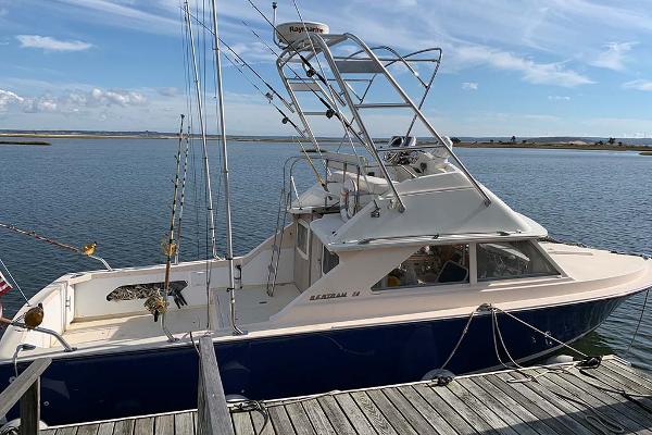 Bertram 28 Flybridge CRUISER 1972 Bertram 28 Flybridge boat docked by the water on a sunny day.