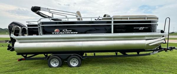 Sun Tracker SportFish 22 DLX 2025 Sun Tracker SportFish 22 DLX pontoon boat on trailer, side view.