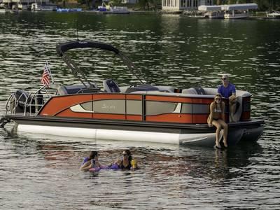 Barletta L25U 2025 Barletta L25U pontoon boat on a lake with people enjoying the water.
